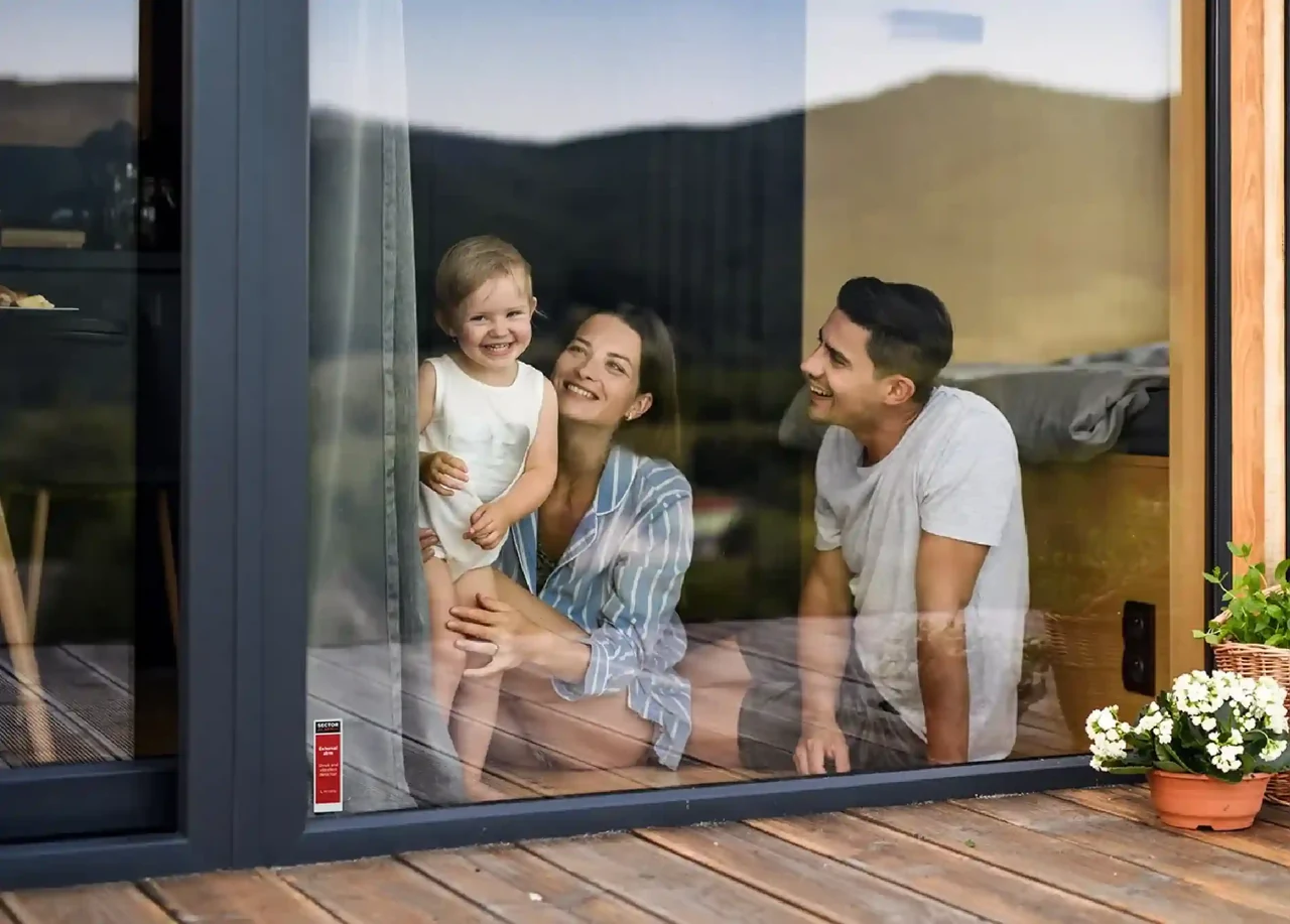 Familia con un niño pequeño en el interior de su vivienda, vista desde el exterior